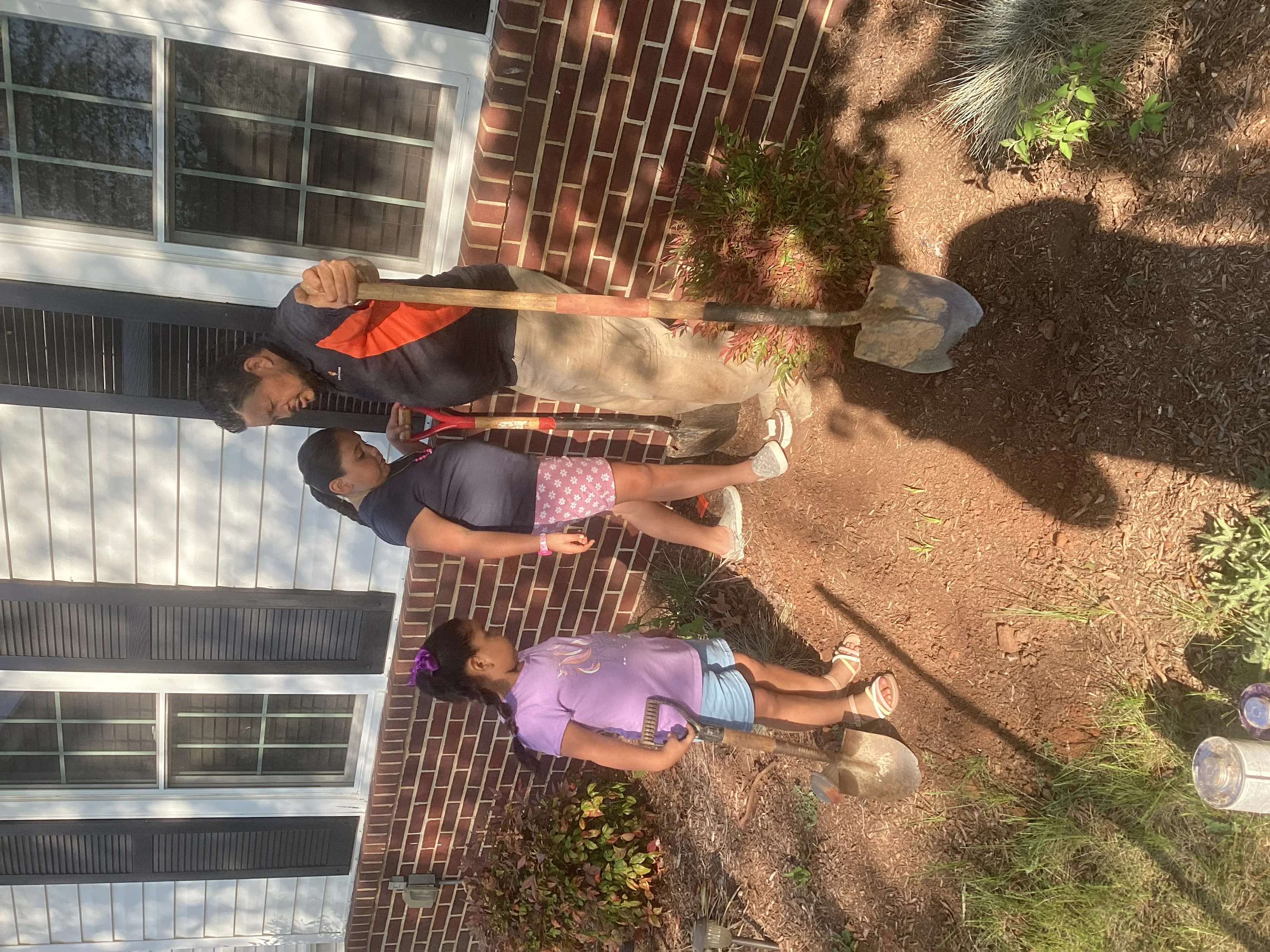 Crew members performing underground pipe excavation and installation at residential property