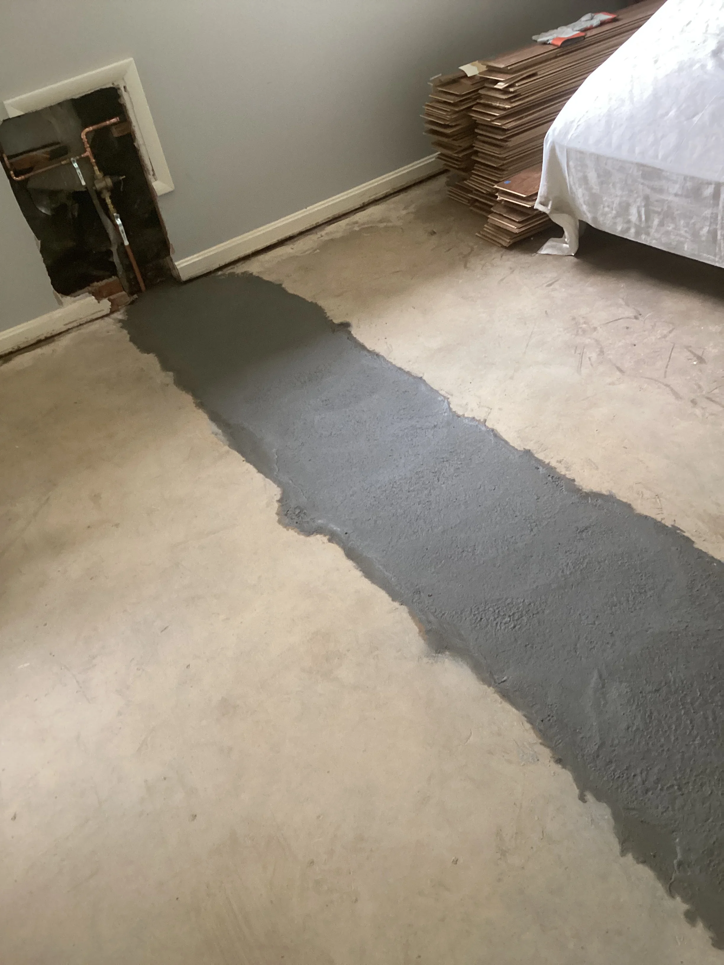 Self-leveling concrete compound applied to interior floor with clean edges and uniform finish