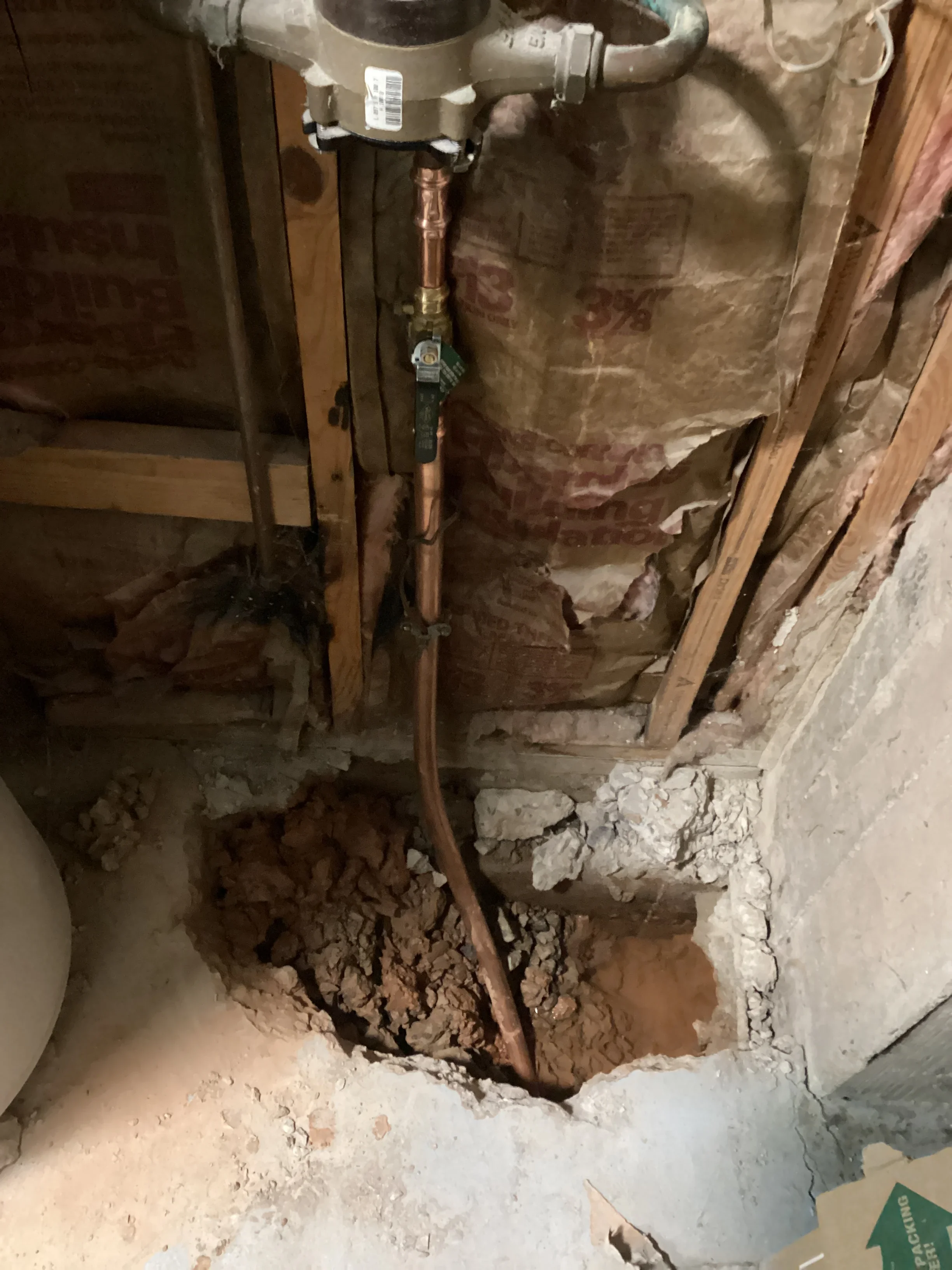 Copper water line installation with shutoff valve in basement foundation opening