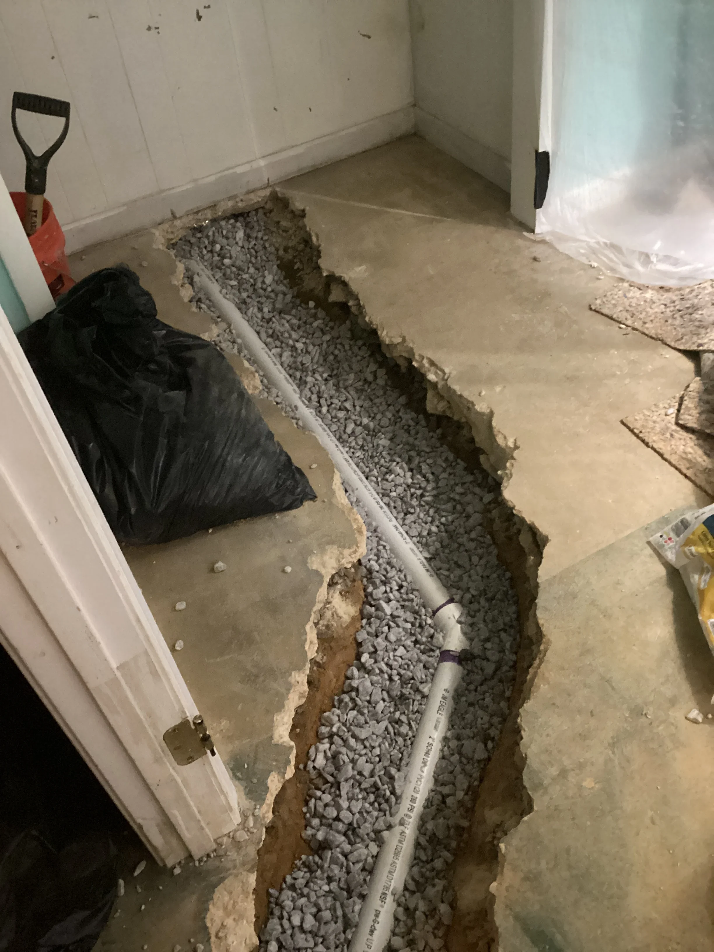 Basement drainage trench with perforated pipe and gravel foundation system