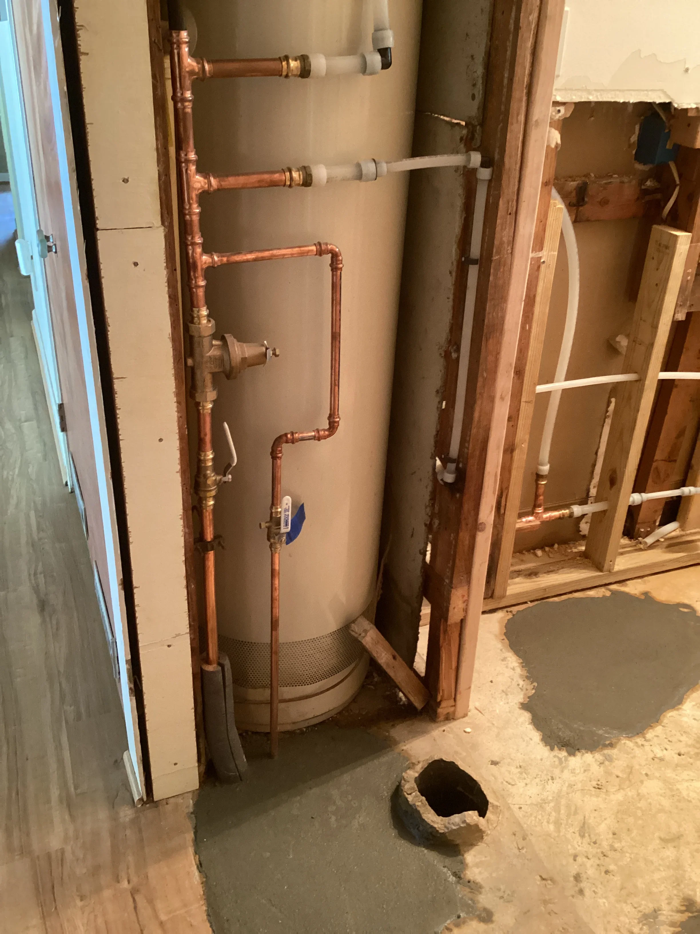 Newly installed water heater with copper piping and shutoff valve in utility space