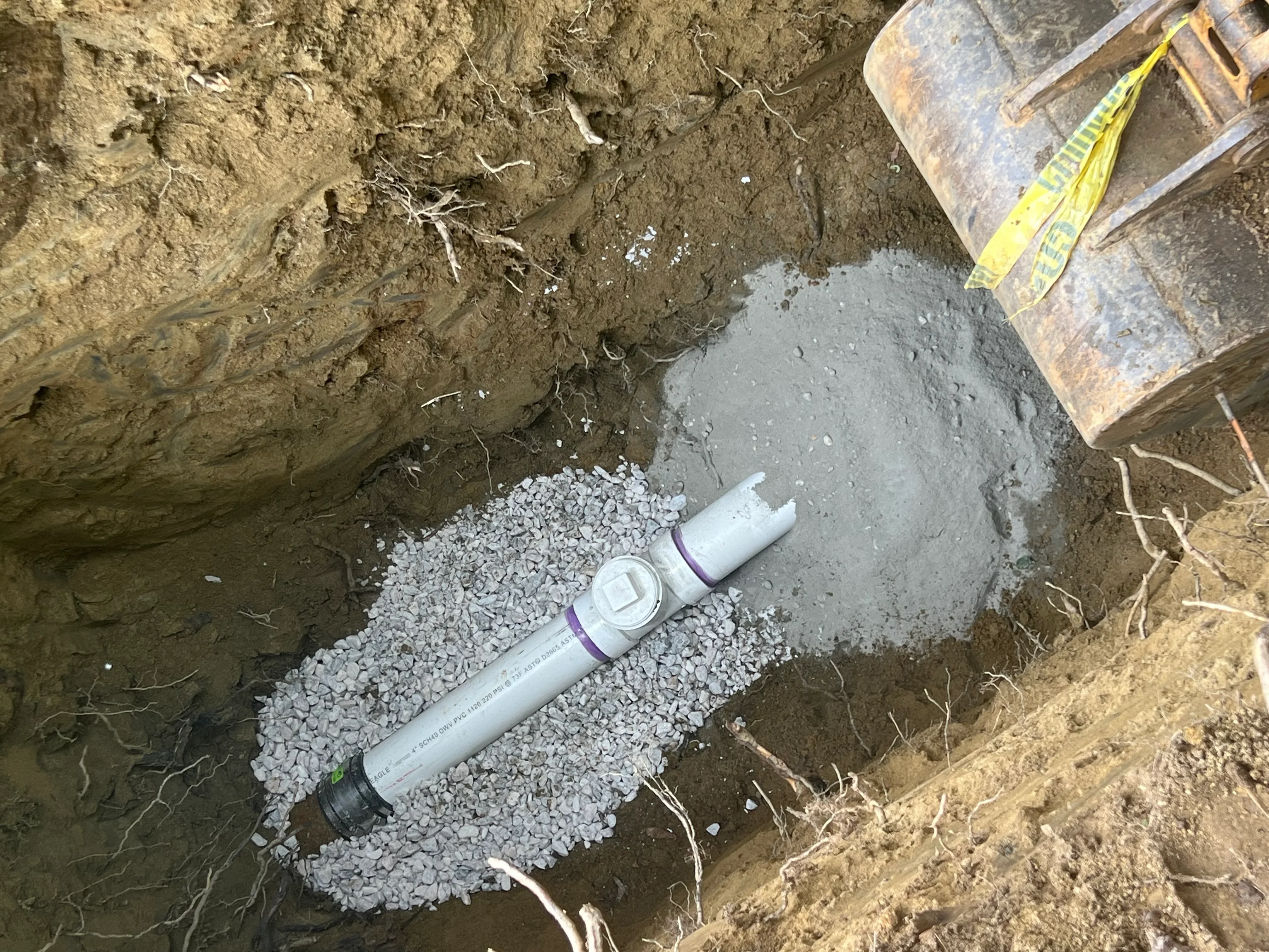 PVC sewer pipe installed in gravel bed during underground utility work